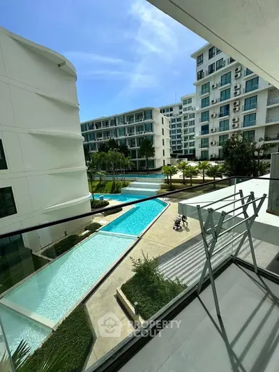 Luxurious condo balcony with stunning pool view and modern architecture