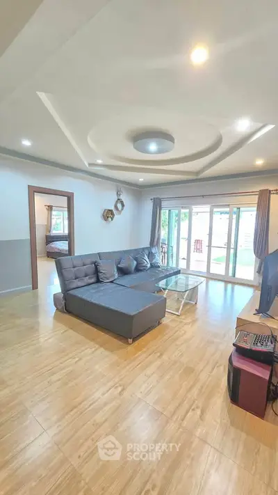 Spacious living room with modern decor and large windows for natural light