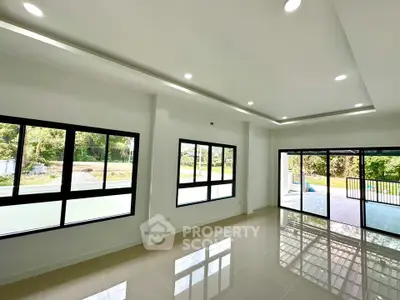 Spacious modern living room with large windows and glossy tiled floors
