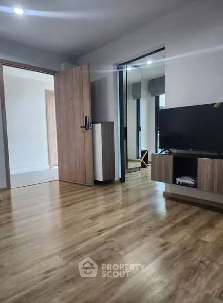 Modern living room with wooden flooring and sleek TV setup