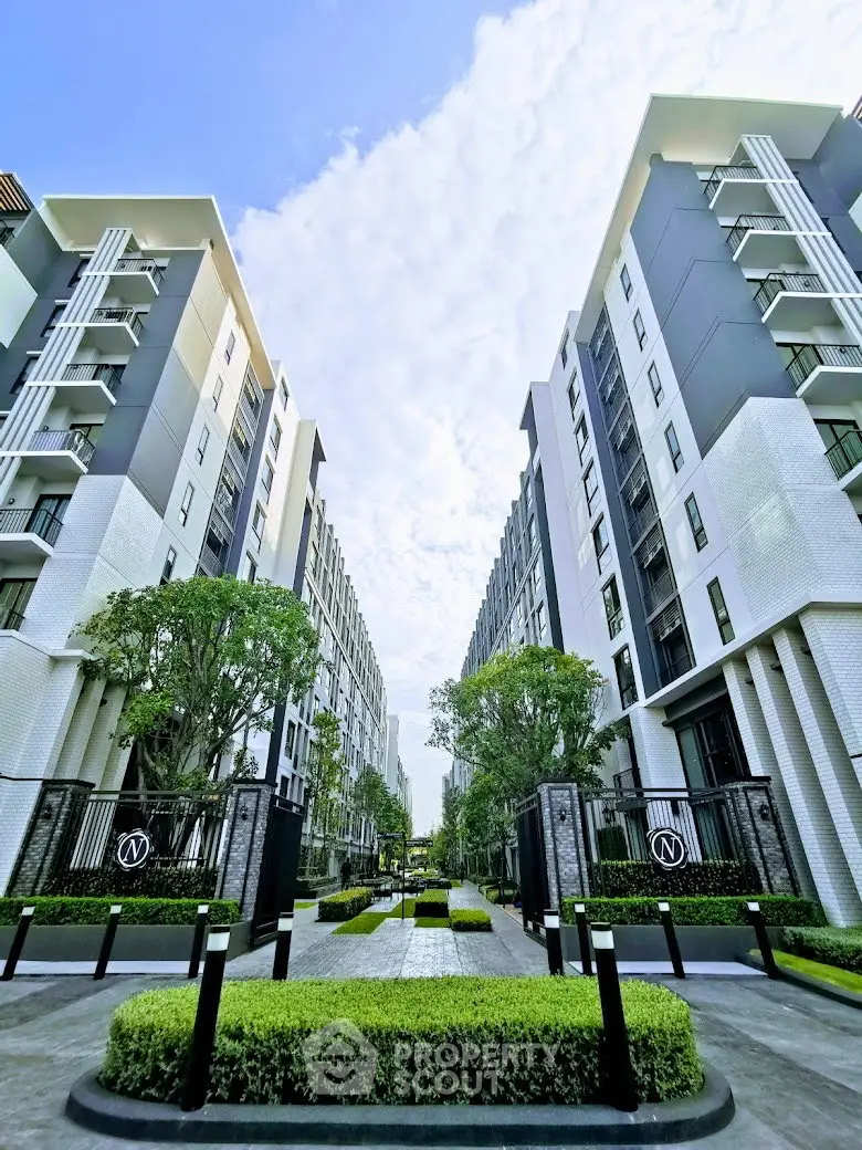 Modern apartment complex with lush landscaping and contemporary architecture.
