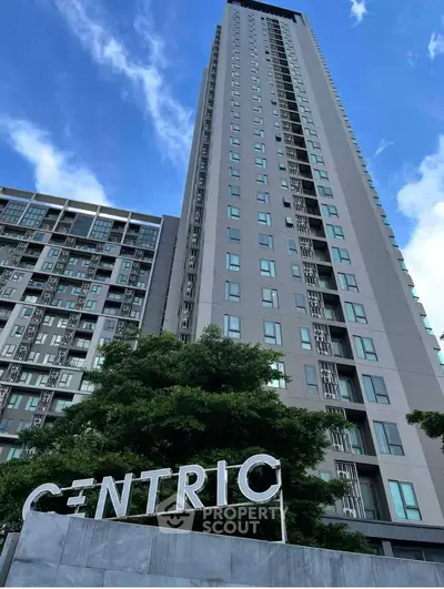Modern high-rise building with sleek design and lush greenery, perfect for urban living.