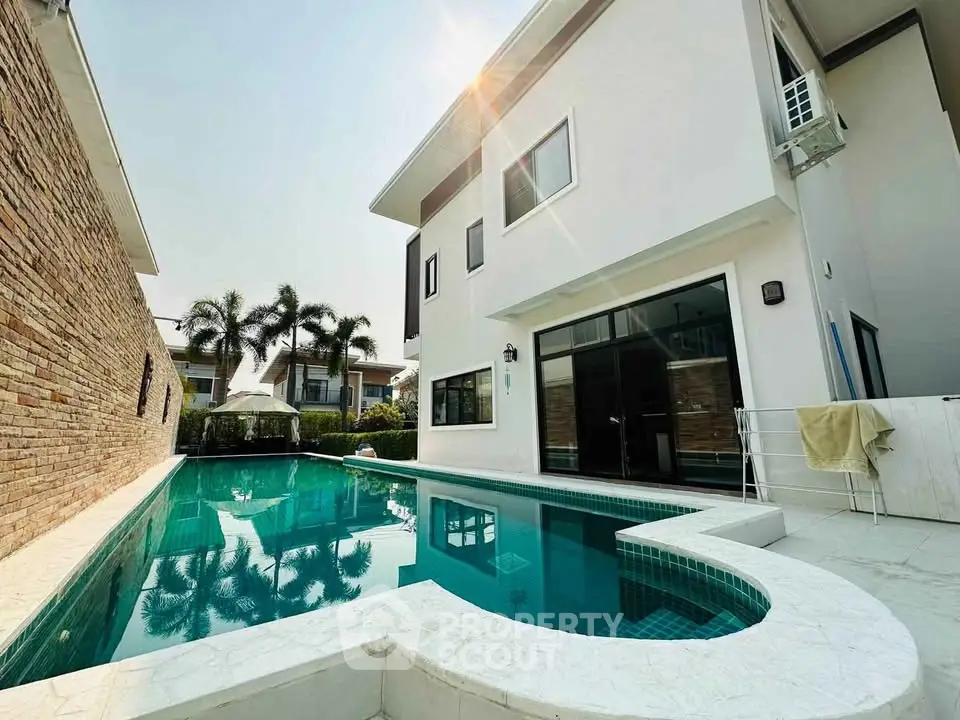 Luxurious modern home with private pool and sunlit exterior, perfect for relaxation and entertainment.