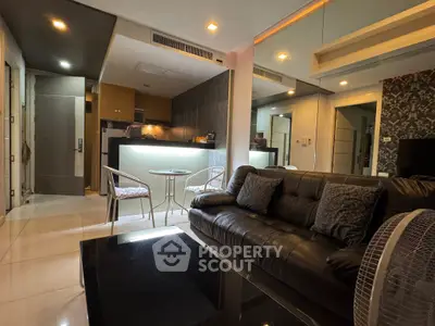Modern living room with sleek black leather sofa and stylish open kitchen