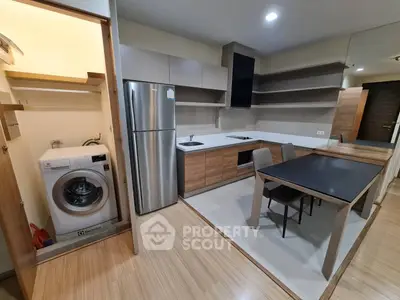 Modern kitchen with sleek appliances and integrated washing machine in stylish apartment