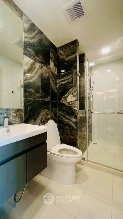 Luxurious modern bathroom with elegant marble wall tiles and sleek fixtures.