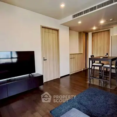 Modern living room with sleek TV setup and stylish dining area, featuring wooden flooring and contemporary design.