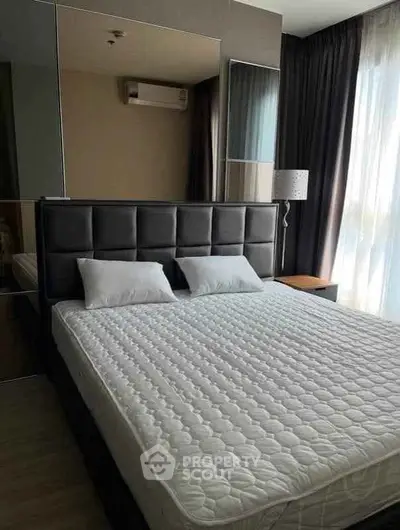 Modern bedroom with stylish decor and large window for natural light.