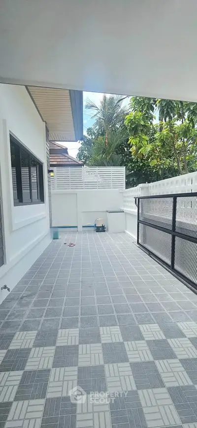 Spacious outdoor patio with tiled flooring and privacy fencing, perfect for relaxation and entertainment.