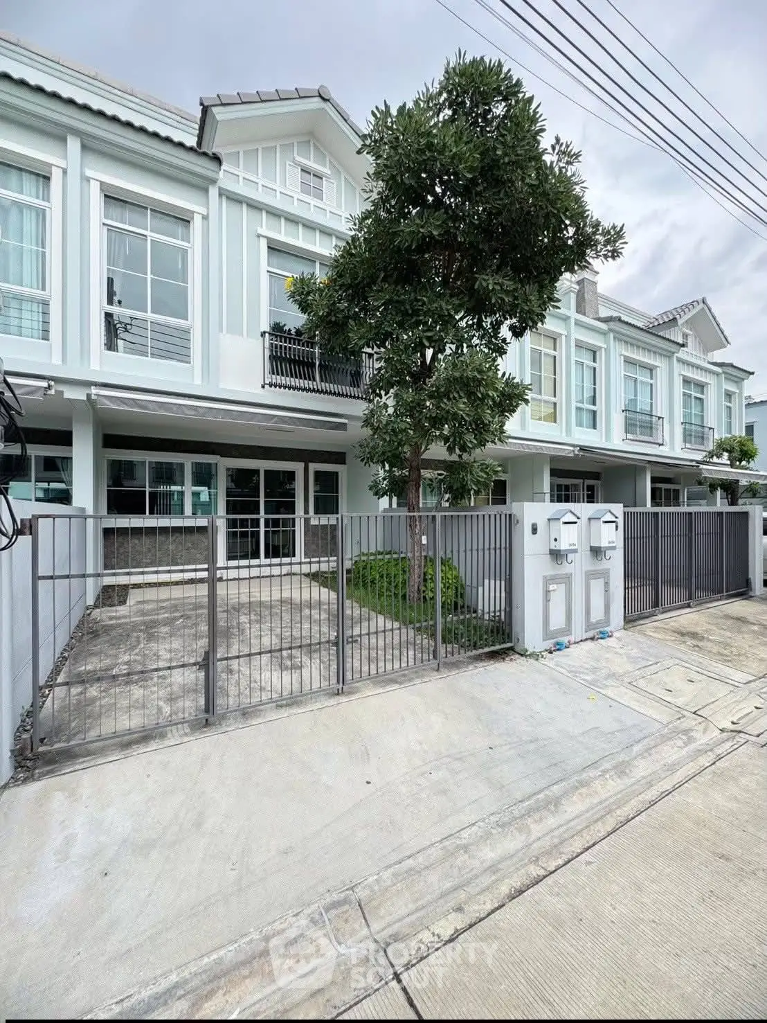 Charming townhouse with modern facade and gated entrance in a serene neighborhood.