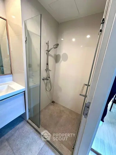 Modern bathroom with sleek shower and elegant vanity in contemporary apartment.