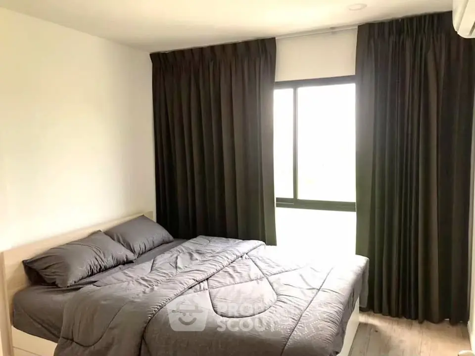 Cozy bedroom with dark curtains and natural light, perfect for relaxation.