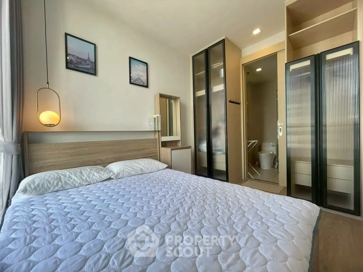 Modern bedroom with stylish decor and ensuite bathroom in a contemporary apartment.