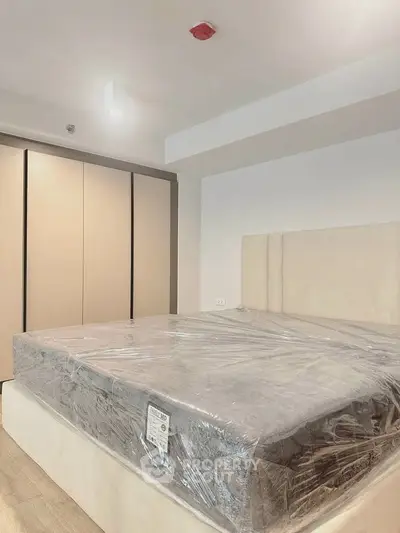 Modern bedroom with sleek design and spacious wardrobe, featuring a new mattress in a stylish apartment.