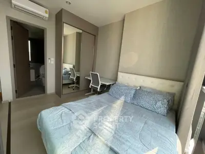 Modern bedroom with natural light, featuring a cozy bed, study desk, and mirrored wardrobe.