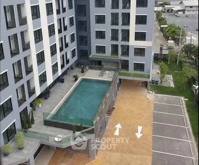 Modern apartment building with pool and parking area