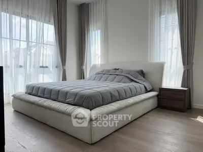 Spacious bedroom with modern decor and large windows for natural light