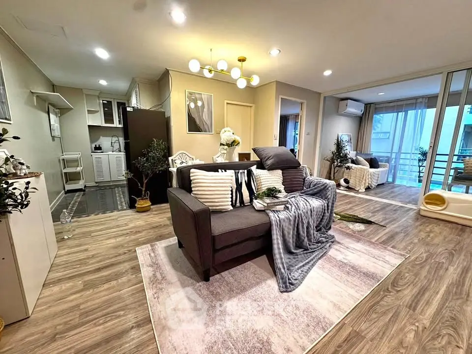 Spacious modern living room with open layout and stylish decor, featuring cozy seating and elegant lighting.