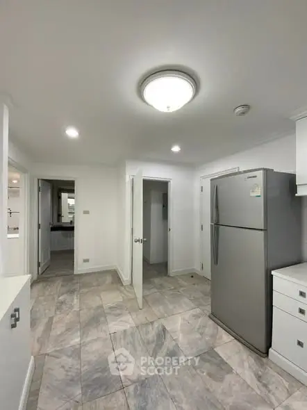 Spacious kitchen with modern fridge and tiled flooring