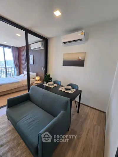 Modern living room with dining area and view into cozy bedroom