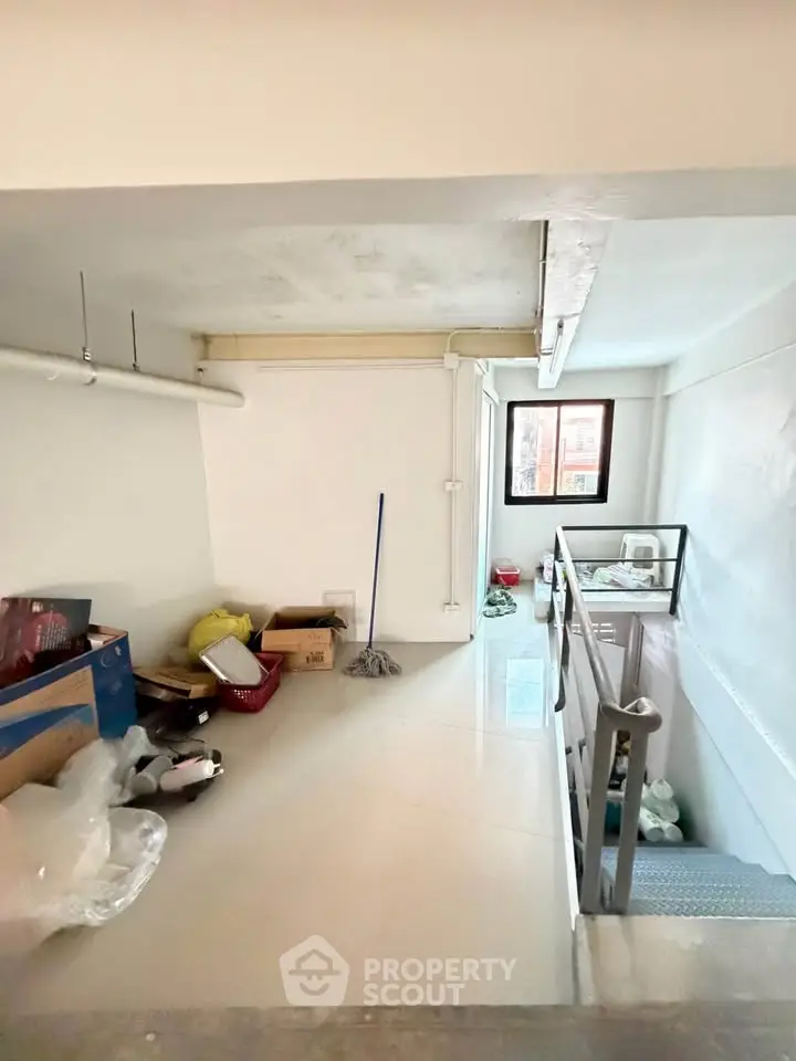 Spacious storage area with natural light and modern railing, ideal for organizing and decluttering.