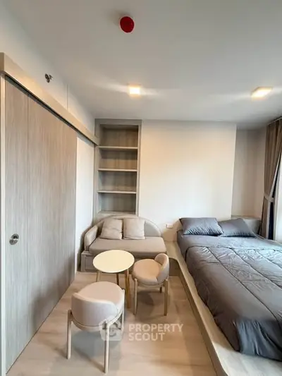Modern bedroom with cozy seating area and stylish decor