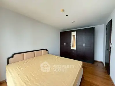 Spacious bedroom with elegant wardrobe and cozy bed in modern apartment.