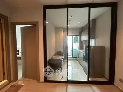 Modern kitchen with glass partition and sleek appliances in a contemporary apartment.