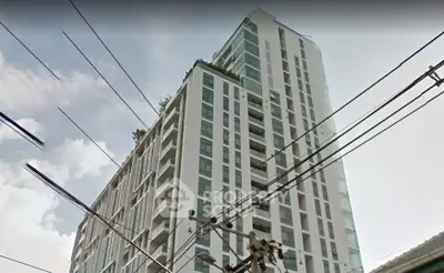 Modern high-rise building with sleek design and large windows in urban setting.