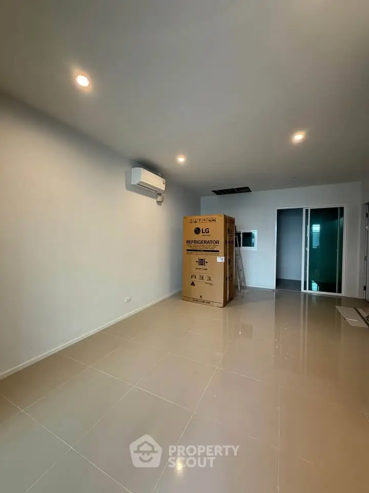 Spacious modern living room with new air conditioning and boxed refrigerator, ready for customization.