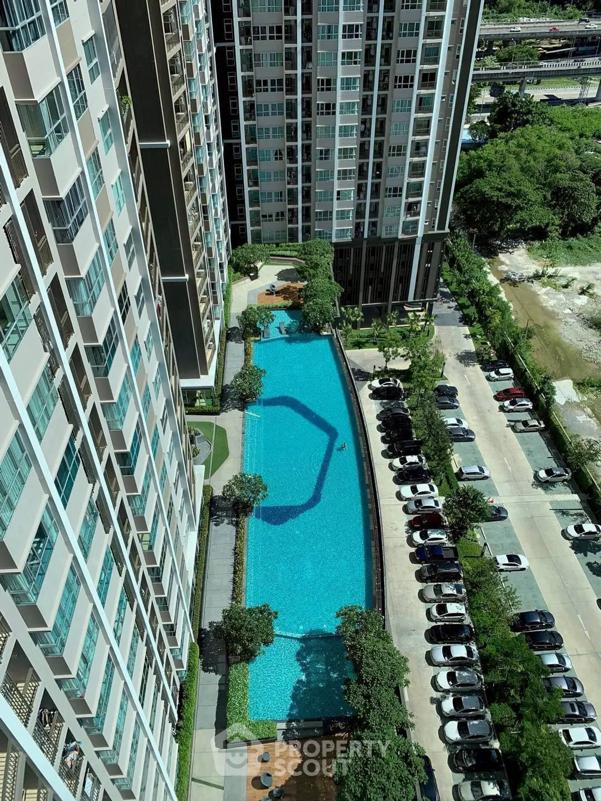 High-rise residential building with a stunning pool view and ample parking space.