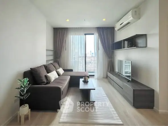 Modern living room with city view, stylish furniture, and natural light.