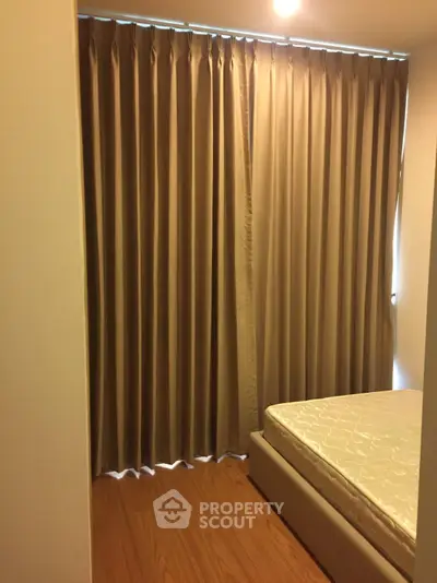 Cozy bedroom with elegant curtains and comfortable mattress, perfect for relaxation.