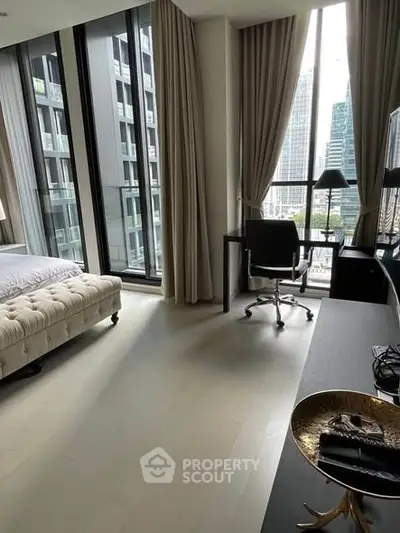 Modern bedroom with city view, featuring large windows and stylish decor.