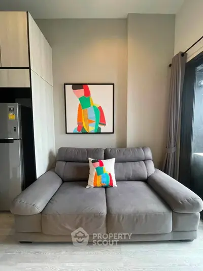 Modern living room with stylish gray sofa and colorful abstract art