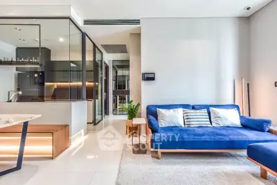 Modern living room with blue sofa and open kitchen layout