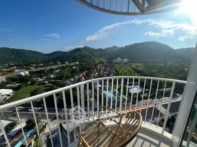 Stunning balcony view overlooking lush green hills and vibrant neighborhood, perfect for relaxation and enjoyment.