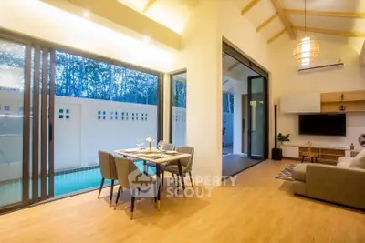Modern living room with open layout and poolside view, featuring elegant dining area and cozy seating.
