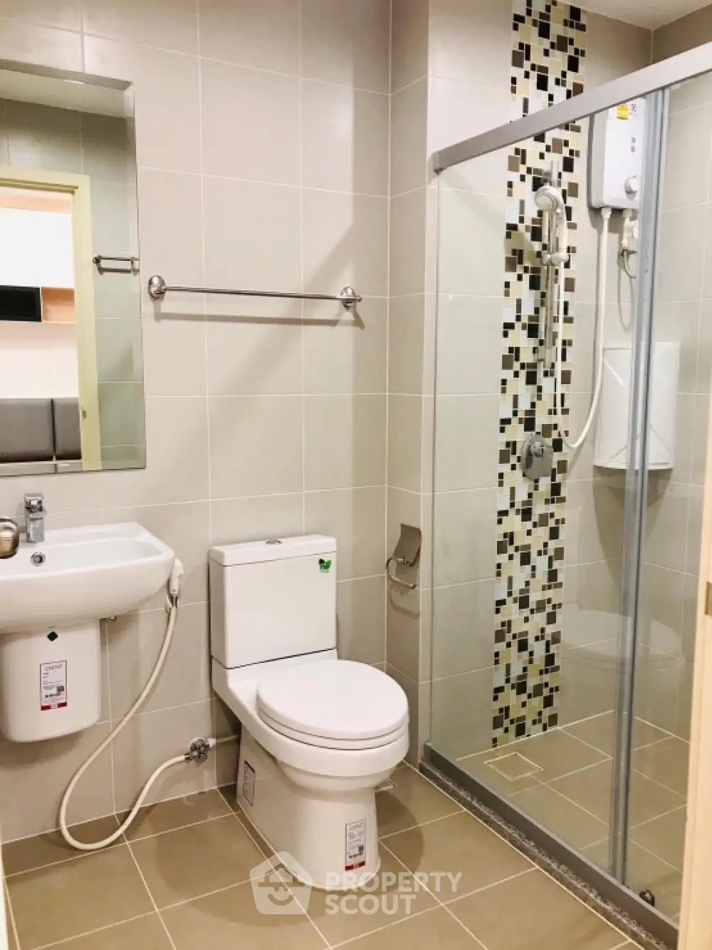 Modern bathroom with glass shower and tiled walls in a stylish apartment.