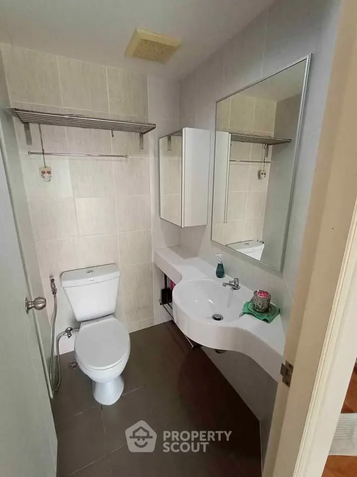 Modern bathroom with sleek fixtures and wall-mounted mirror in a compact space.