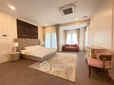 Luxurious bedroom with elegant decor and plush furnishings, featuring a cozy seating area and ample natural light.
