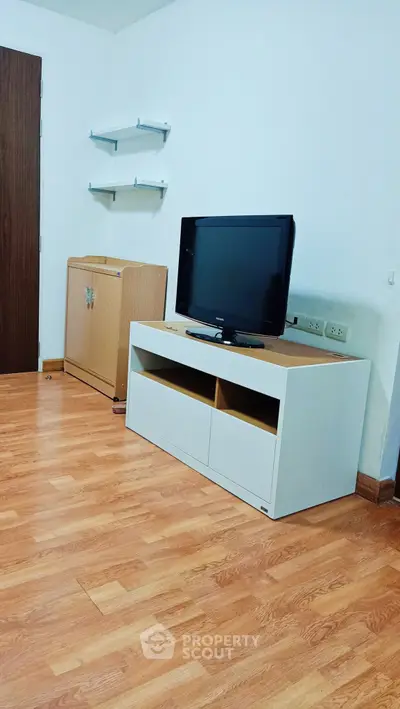 Modern living room with wooden flooring and sleek TV stand, perfect for cozy entertainment.