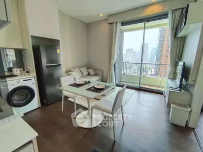 Modern open-plan living room with city view balcony, featuring sleek kitchen and cozy dining area.