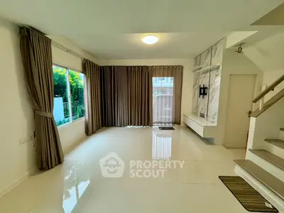 Spacious living room with large windows and elegant curtains