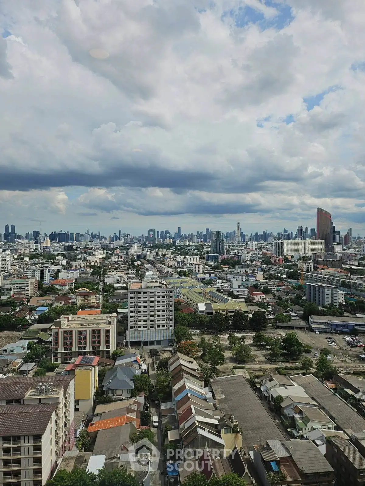 Stunning cityscape view from high-rise building showcasing urban skyline and dramatic clouds.