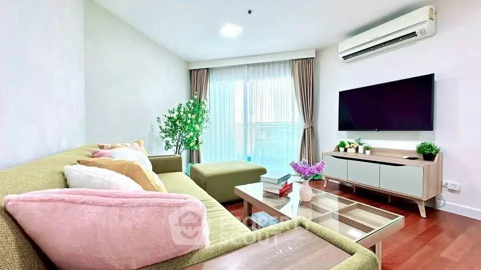 Modern living room with stylish furniture and large window, featuring a cozy sofa and flat-screen TV.