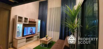 Cozy living room with modern entertainment unit, plush sofa, and vibrant indoor greenery, perfect for relaxation and hosting guests.