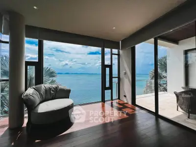Luxurious oceanfront living room with panoramic sea views and elegant wooden flooring.