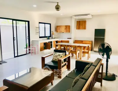 Spacious open-plan living room with modern kitchen and stylish wooden furniture.