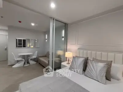Modern bedroom with elegant decor and cozy seating area in open layout.